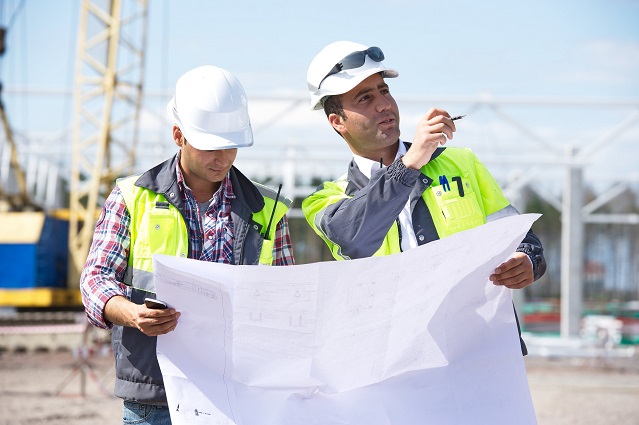 Engineers review a plan at construction